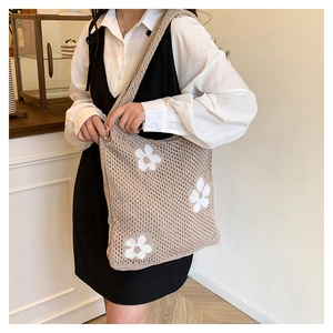 Detailansicht der handgefertigten gehäkelten Stricktasche mit weißen Blumenmustern