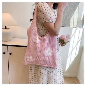 Detailed shot of pink crochet tote bag with white floral pattern on woven fabric