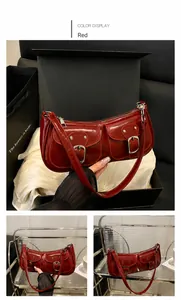 Détail d'un sac sous les aisselles rouge vintage avec boucles argentées et poches à rabat