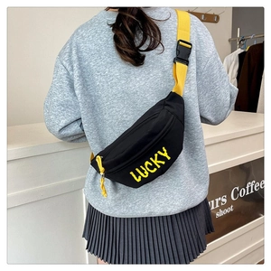 Detail of a black nylon crossbody bag with yellow LUCKY logo and wide shoulder strap