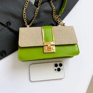 Détail d'un sac bandoulière en cuir vert et tissage beige avec un smartphone pour comparer la taille
