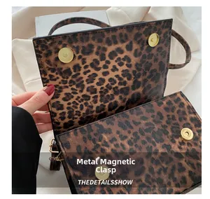Detailansicht der Handtasche mit Leopardenmuster und goldenem Magnetverschluss aus Metall