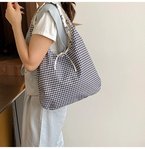 Detail of checkered canvas tote bag with drawstring closure and bow print lining