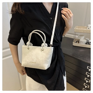 Détail du sac à main crème à motif serpent avec lettrage Fashion doré et finitions