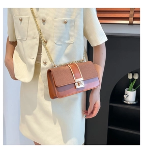 Détail du sac chaîne patchwork vintage avec boucle dorée sur tenue en tweed