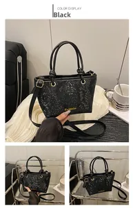 Détails du sac seau noir motif serpent avec fermeture dorée et bandoulière réglable