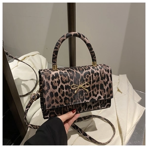 Detail der Leopardenmuster-Handtasche mit goldener Schleife und hochwertiger Lederstruktur
