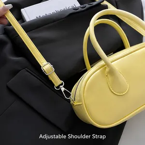 Detail of adjustable shoulder strap with silver hardware on yellow Boston bag