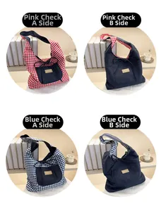 Détail du sac cabas réversible en toile avec motif à carreaux et poche décorative à nœud