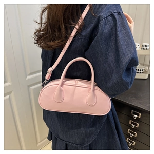 Detail view of a pink oval Boston bag showing the smooth PU material and shoulder strap