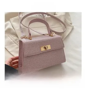 Detailed view of pink woven texture handbag with elegant gold twist lock and handle