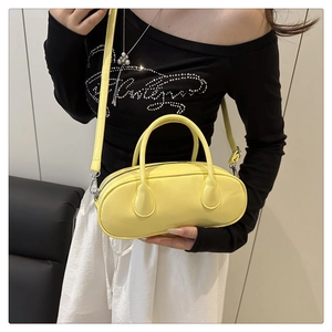Detailed view of bright yellow Boston bag with silver zipper and glossy leather finish