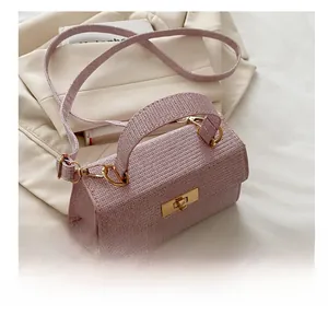 Detail of pink tweed handbag with golden twist lock and reinforced top handle