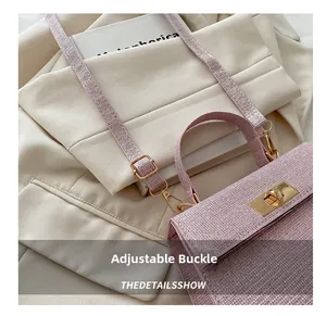 Detail of light pink tweed handbag showing the gold twist lock and adjustable strap buckle