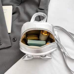 Silver mini backpack interior view showing capacity for lipstick and cosmetics