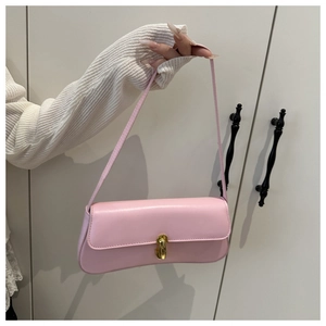 Dettaglio della borsa baguette rosa con trama in pelle e chiusura a girello dorata
