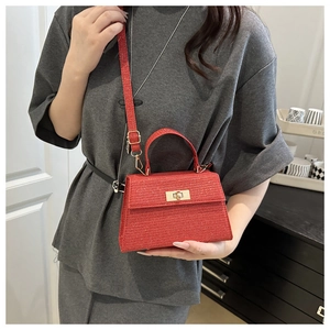 Detail of red glitter trapezoid handbag with gold twist lock and detachable shoulder strap