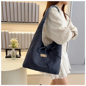 Detail van blauwe canvas draagtas met een strik en Fashion & Bag label decoratie