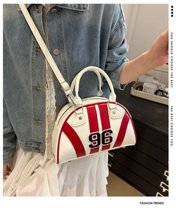 Détail du sac bowling rouge et blanc avec badge 96 porté avec une bandoulière