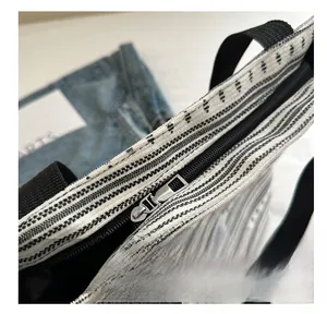 Détail de la fermeture éclair en métal argenté d'un sac cabas en toile à rayures