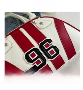 Détail du sac en cuir blanc avec rayures rouges, patch numéro 96 et rivets étoiles