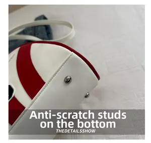 Vue détaillée du fond du sac en cuir rouge et blanc avec des clous de protection en métal