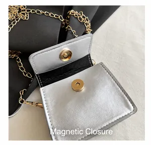 Close-up of the golden magnetic buckle and silver leather texture on a mini bag