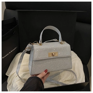 Silver glitter mini Kelly bag with gold metal lock in a black gift box packaging