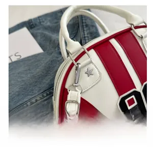 Détails des finitions argentées et du rivet en étoile sur le sac Boston rayé