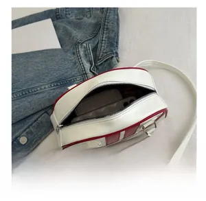 Gros plan de l'intérieur du sac en cuir rouge et blanc montrant sa grande capacité