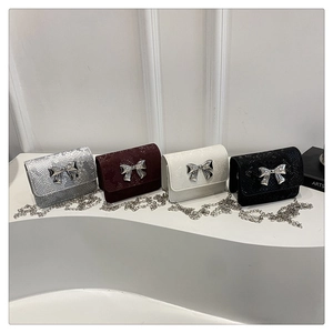 Detalle de mini bolsos bandolera con estampado de serpiente y hebillas de lazo plateado
