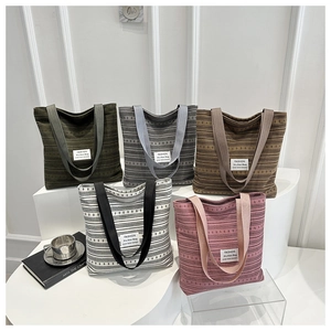 Gros plan de sacs cabas en maille rayée de cinq couleurs avec étiquettes de mode