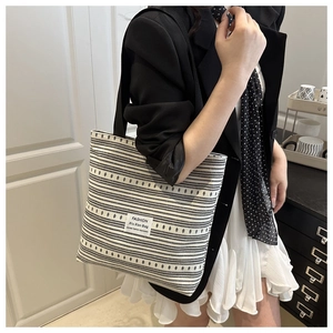 Gros plan du sac fourre-tout en toile à rayures noires et blanches avec étiquette mode