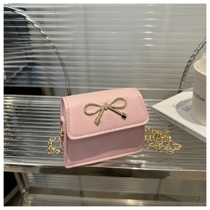 Detailed close-up of a pink mini crossbody bag featuring a golden bow magnetic buckle