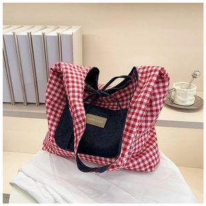 Detail van de rood-witte geruite tote bag met blauwe denim zak en lederen merklabel