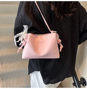 Pink cloud crossbody bag with drawstring detail and elegant pearl lace charm on strap