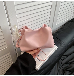 Detalle de bolso nube rosa con textura PU mate y colgante de perla con lazo de encaje