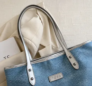 Close-up of light blue denim tote with sparkling rhinestones and silver leather handle