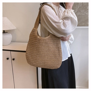 Detail of hand-woven straw shoulder bag with natural brown fibers and dense knit texture