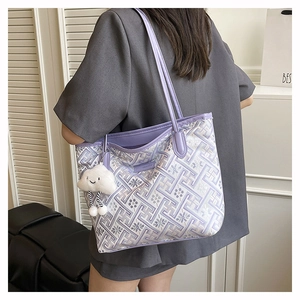 Detail of purple woven jacquard tote bag with cloud charm on a grey suit jacket