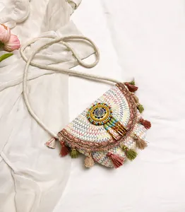 Detail of bohemian woven saddle bag featuring colorful beads and vibrant fringe tassels
