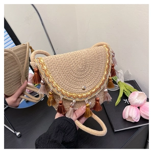 Detail of bohemian straw saddle bag with colorful tassels and gold wave trim