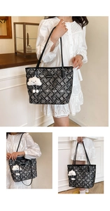 Close-up of black tote bag with white geometric patterns and a cloud plush charm