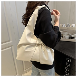 Close-up of stylish cream white PU leather shoulder bag featuring a large decorative bow