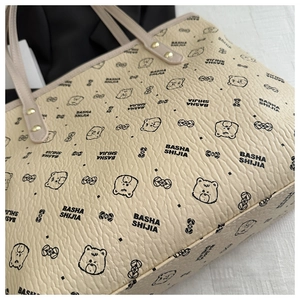 Detail of lychee pattern faux leather tote bag with cute cartoon bear prints