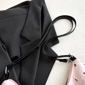 Dettaglio della borsa rosa a pieghe con piccoli motivi neri e chiusura a zip