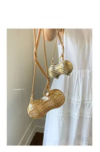 Detailed macro view of a golden peanut-shaped clutch bag with luxury rhinestones and chain