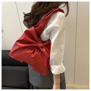 Mannequin portant un grand sac cabas rouge en forme de nœud avec texture cuir souple