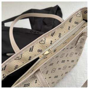 Close-up of the large tote bag with cartoon bear print and secure gold zipper closure