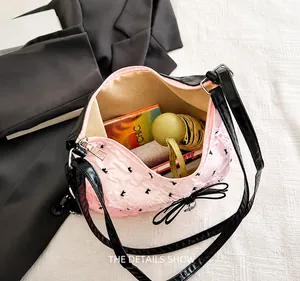 Dettaglio della capienza della borsa rosa con fiocco contenente ombrello e cellulare